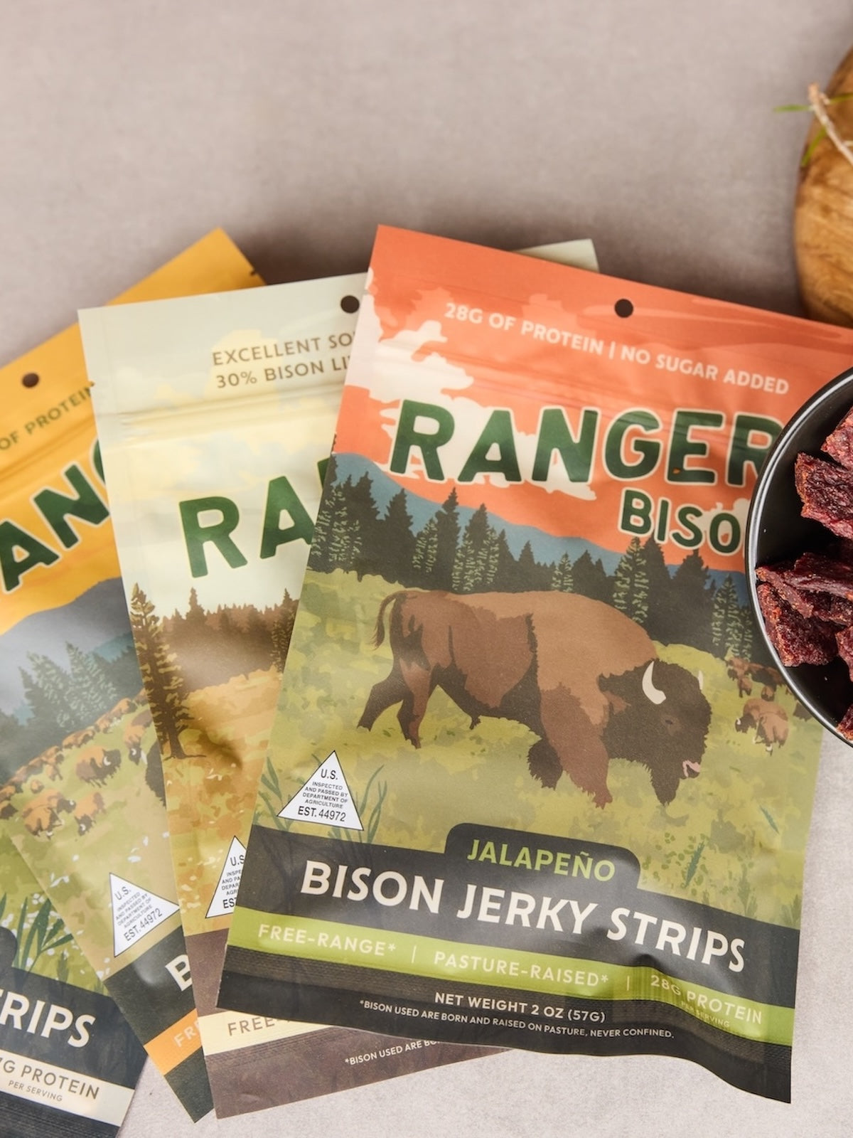 Packages of Ranger Bison jerky strips with a bison illustration on a neutral background