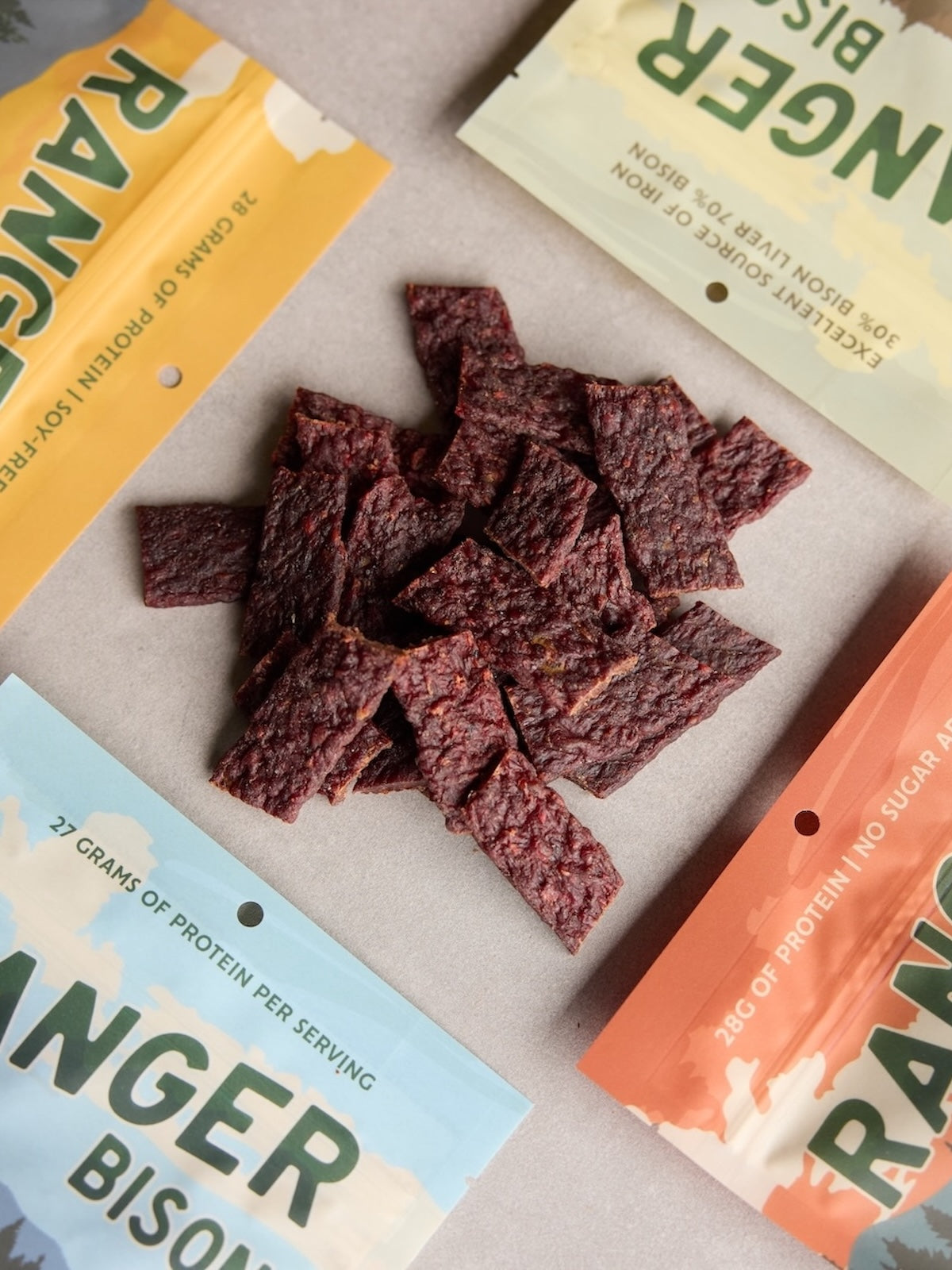 Dried beef jerky with Ranger Bison packaging on a gray surface